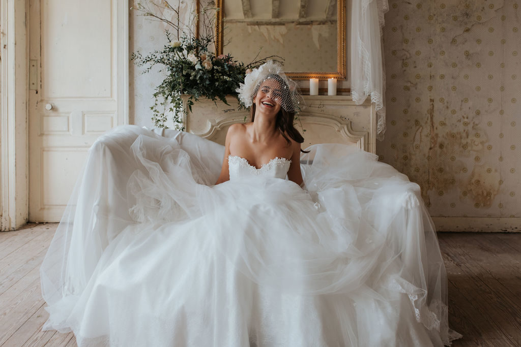 femme avec une robe de mariée bohème et romantique assise sur un canapé